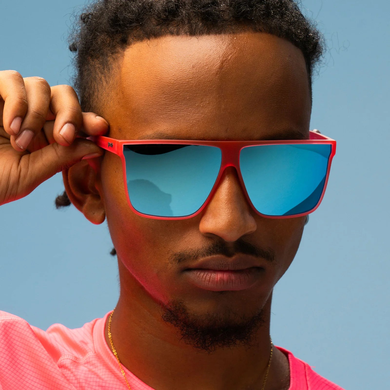Hot pink sunglasses with mirrored reflective lenses in teal. Flat-top frames with a wider fit. No slip, no bounce, all polarised.